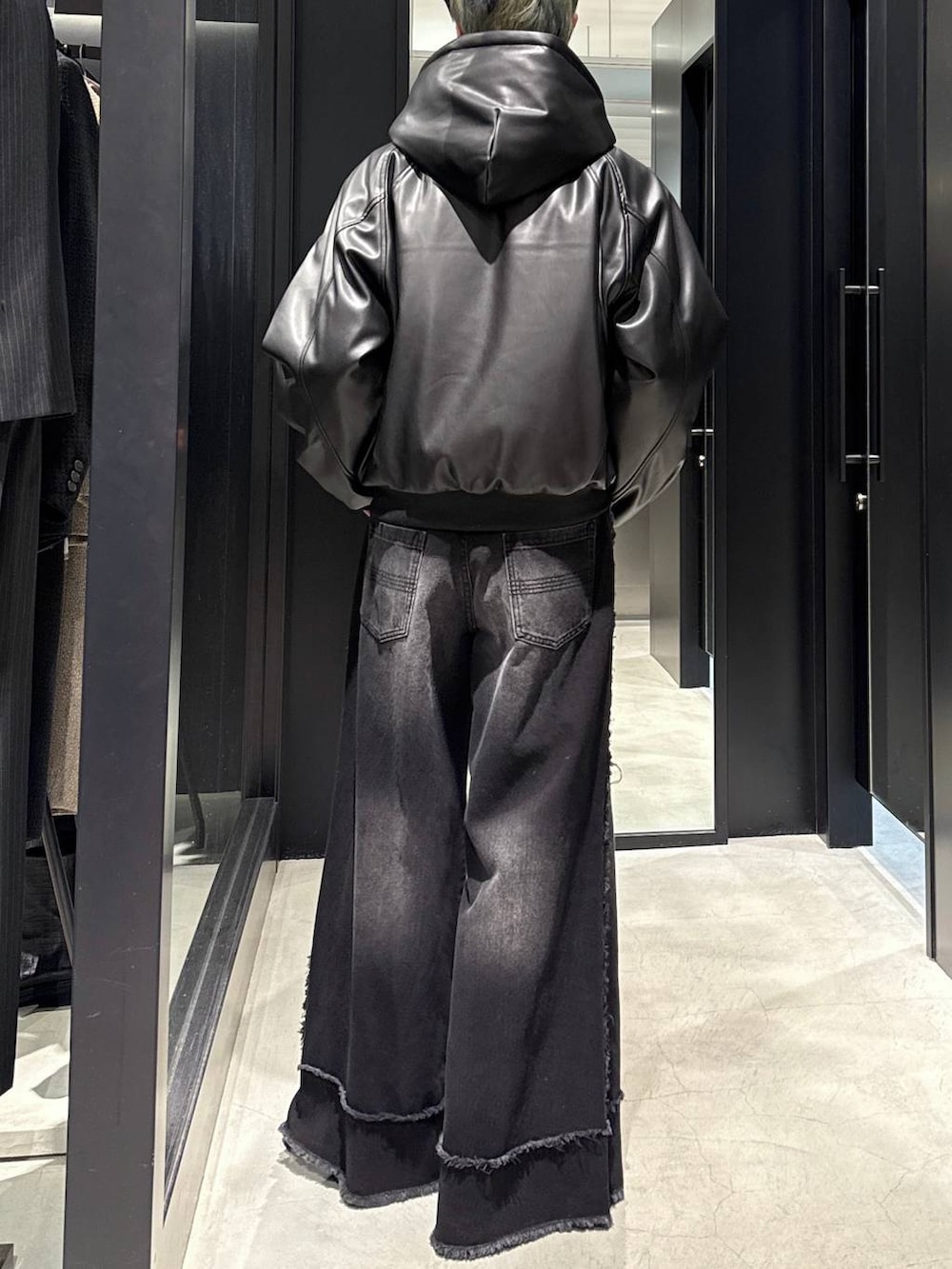 ブラック系のデニムパンツ、ブラック系のブルゾン、シルバー系のネックレスを着用したメンズの冬コーディネートの3枚目の写真