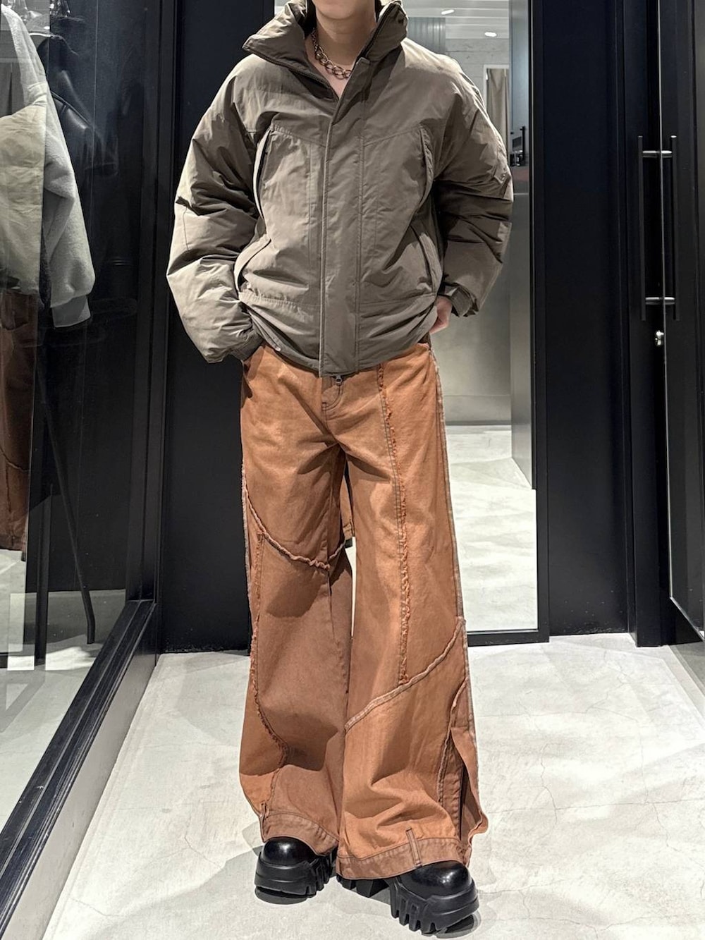 ブラウン系のダウンジャケット/コート、オレンジ系のデニムパンツ、シルバー系のネックレスを着用したメンズの冬コーディネートの3枚目の写真