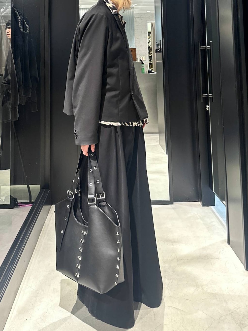 ブラック系のスラックス、ブラック系のテーラードジャケット、ブラック系のトートバッグを着用したメンズの秋コーディネートの2枚目の写真