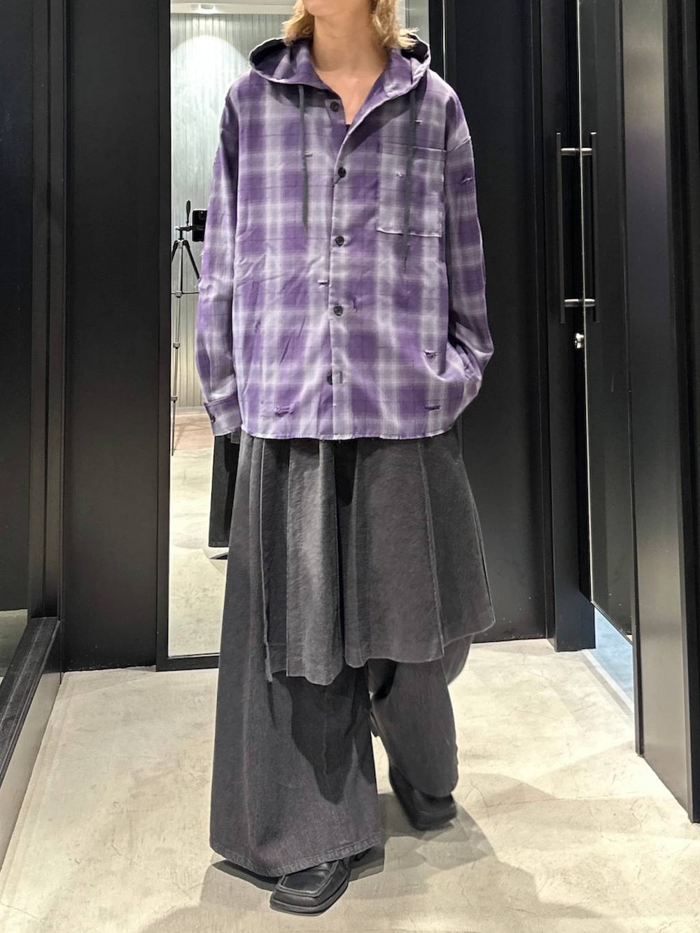 グレー系のスラックス、パープル系のパーカー、ブラック系のキャップを着用したメンズの秋コーディネートの3枚目の写真