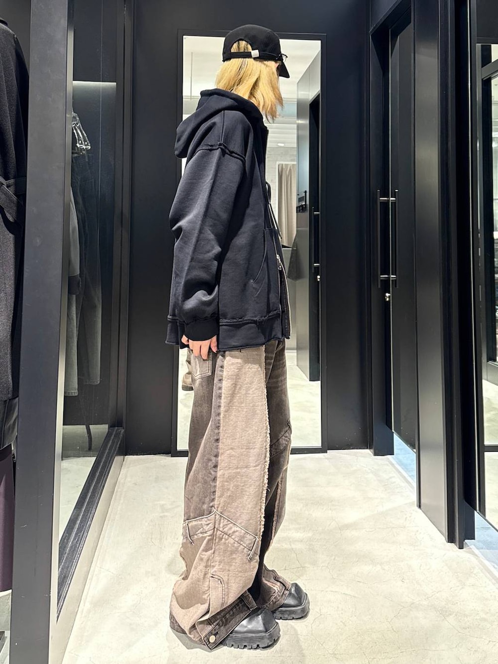 ブラウン系のデニムパンツ、ブラック系のパーカー、ブラック系のキャップを着用したメンズの秋コーディネートの2枚目の写真