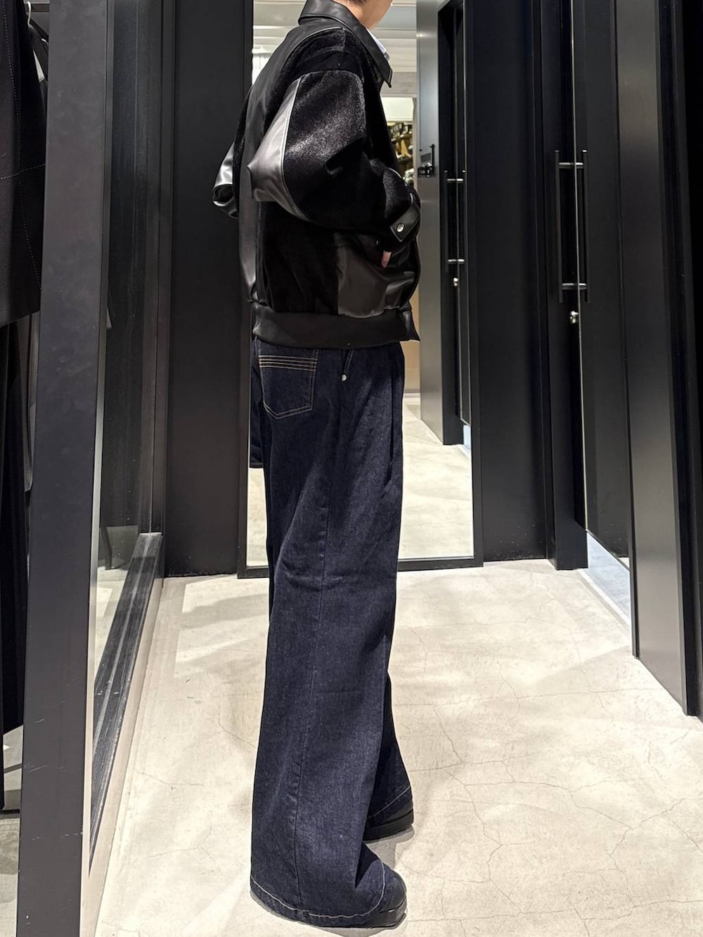 ブラック系のブーツ、ブラック系のブルゾン、ブルー系のデニムパンツを着用したメンズの冬コーディネートの2枚目の写真