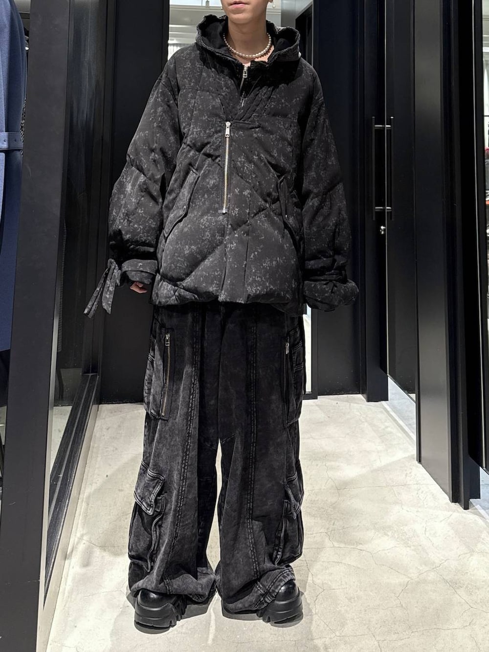 ブラック系のスウェットパンツ、ブラック系のパーカー、グレー系のダウンジャケット/コートを着用したメンズの冬コーディネートの4枚目の写真