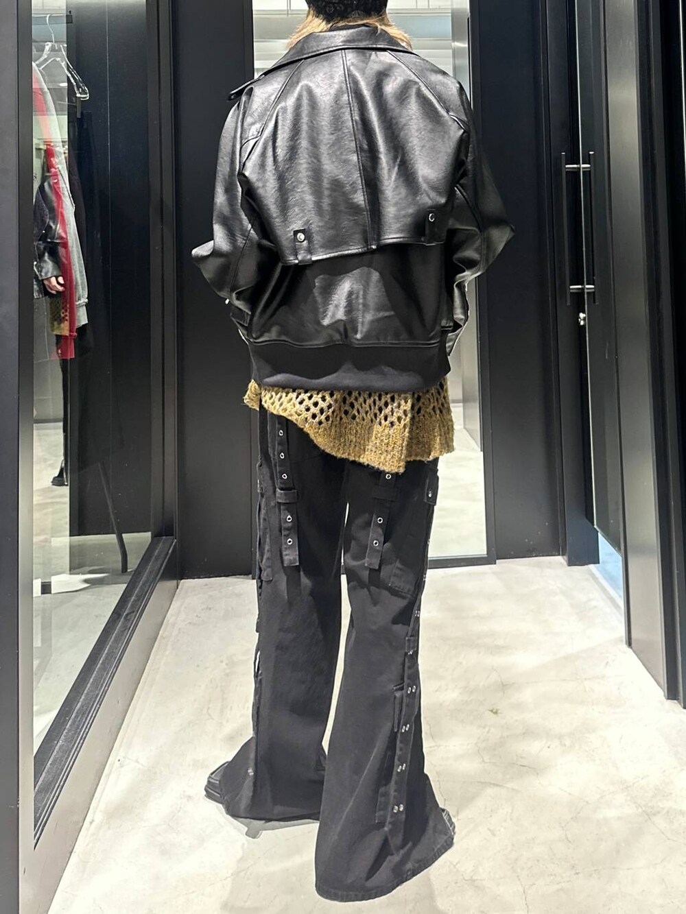 イエロー系のニット/セーター、ブラック系のデニムパンツ、ブラック系のブルゾンを着用したメンズの秋コーディネートの4枚目の写真