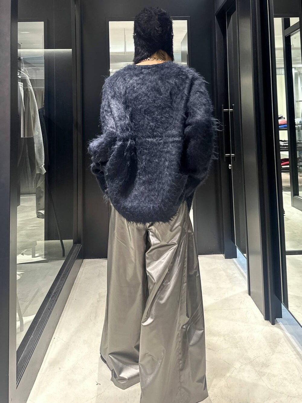 シルバー系のスラックス、ブルー系のカーディガン/ボレロ、ブラック系のドレスシューズを着用したメンズの秋コーディネートの4枚目の写真