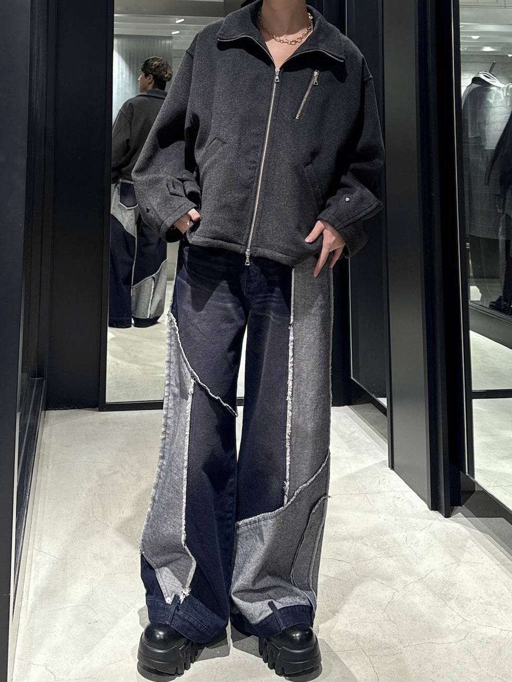 グレー系のブルゾン、ブルー系のデニムパンツを着用したメンズの秋コーディネートの4枚目の写真