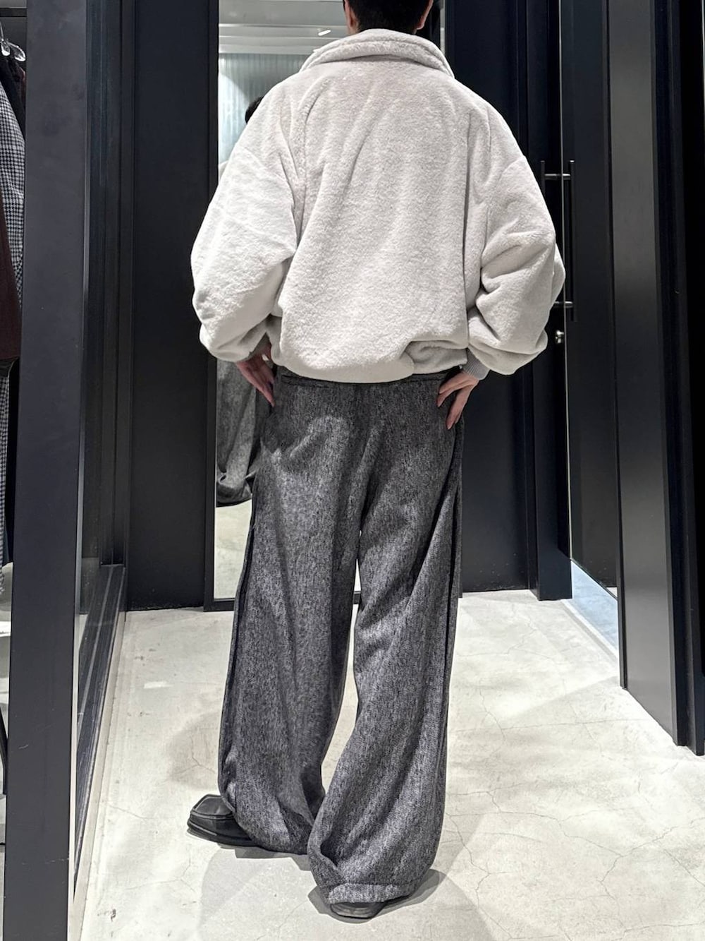 グレー系のブルゾン、ブラック系のスラックスを着用したメンズの秋コーディネートの3枚目の写真