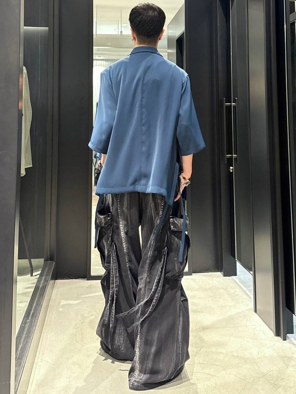 ブラック系のカーゴパンツ、ブラック系のサンダル、ブルー系のテーラードジャケットを着用したメンズの夏コーディネートの2枚目の写真