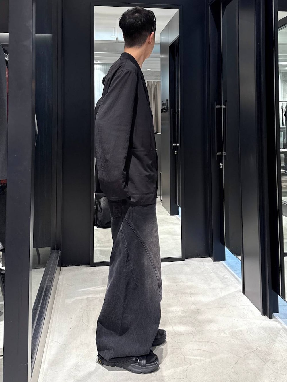 ブラック系のデニムパンツ、ブラック系のサンダル、ブラック系のタンクトップを着用したメンズの夏コーディネートの2枚目の写真