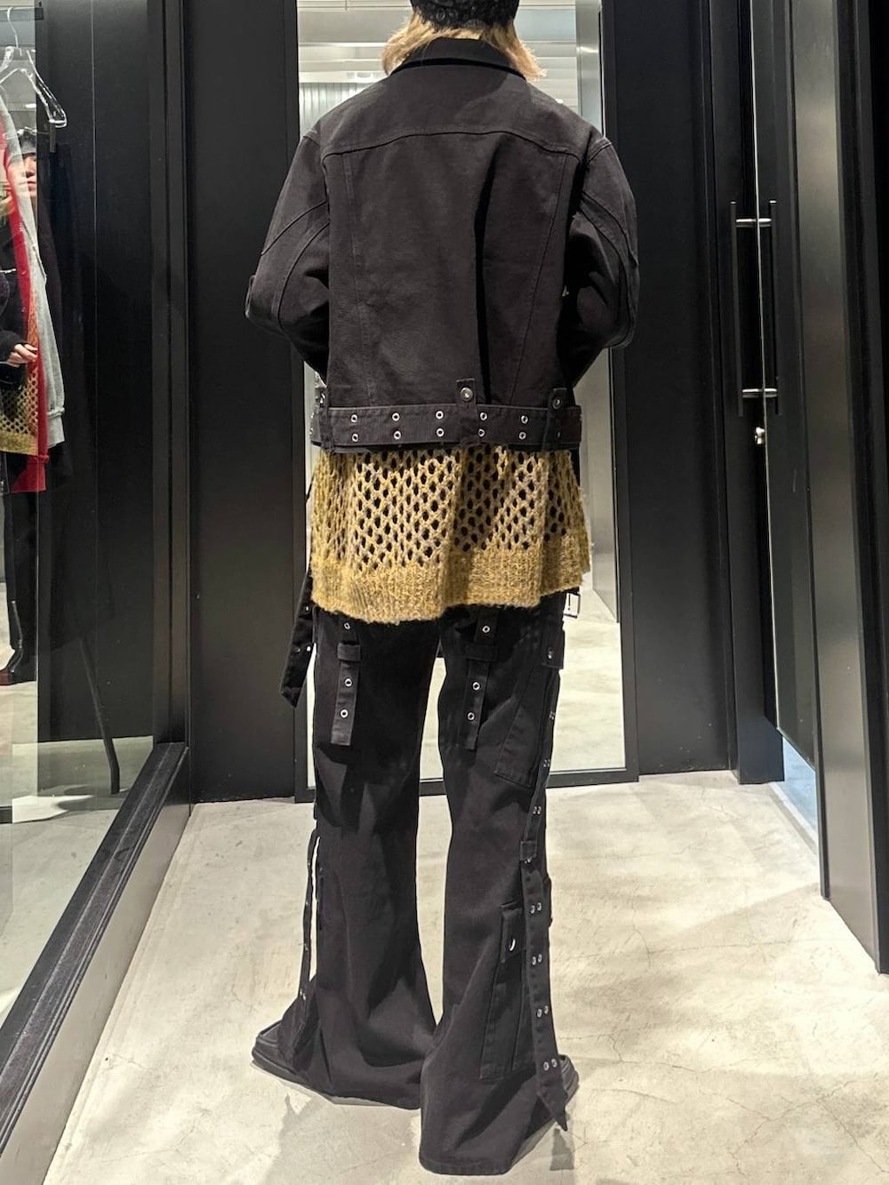 ブラック系のデニムパンツ、イエロー系のニット/セーター、ブラック系のデニムジャケットを着用したメンズの秋コーディネートの4枚目の写真