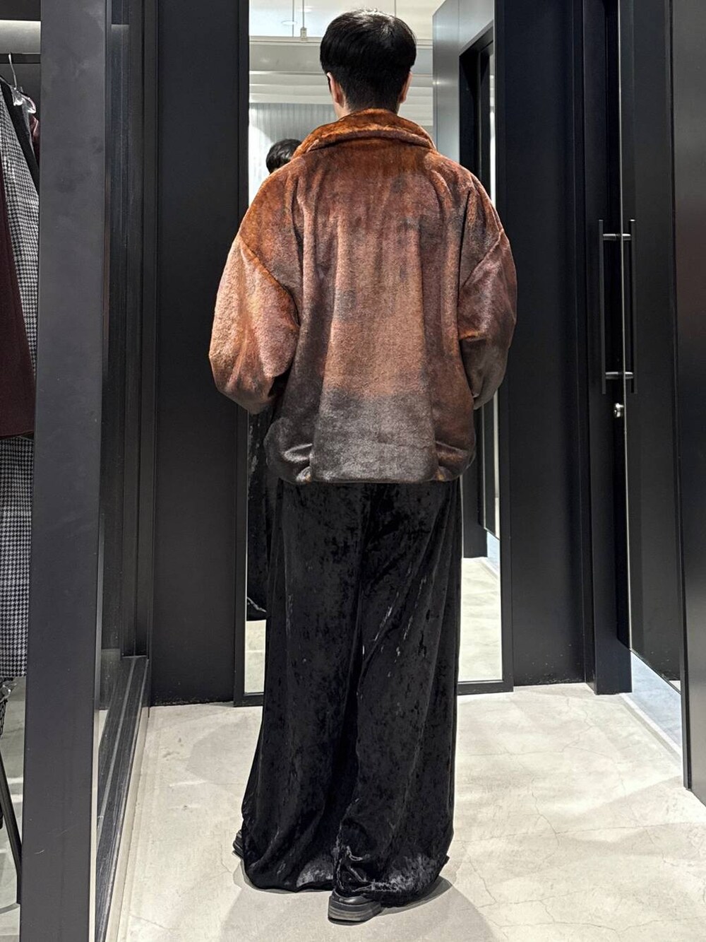 オレンジ系のブルゾン、ブラック系のその他パンツを着用したメンズの秋コーディネートの4枚目の写真