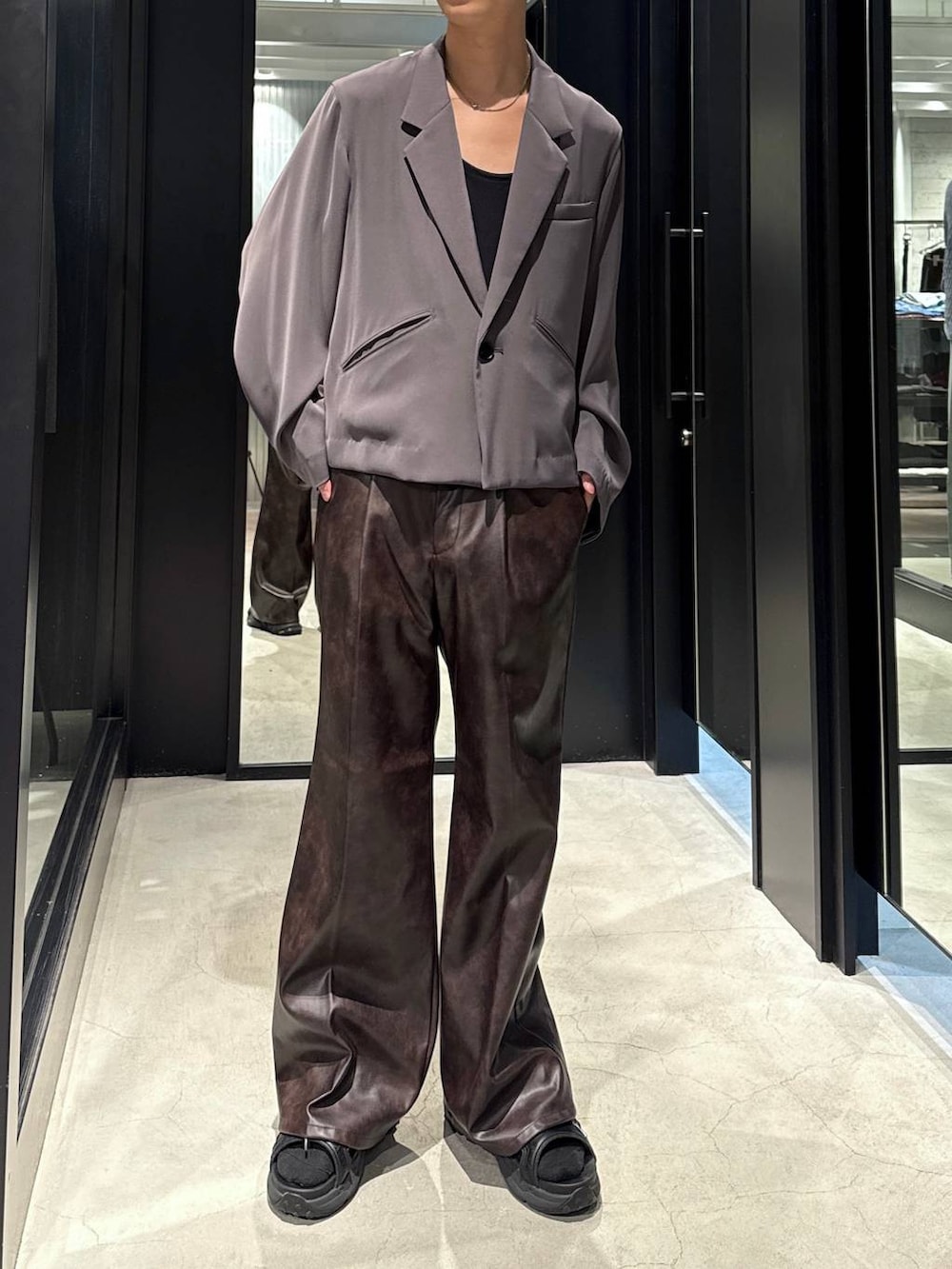 ブラック系のサンダル、ブラック系のタンクトップ、グレー系のテーラードジャケットを着用したメンズの夏コーディネートの2枚目の写真