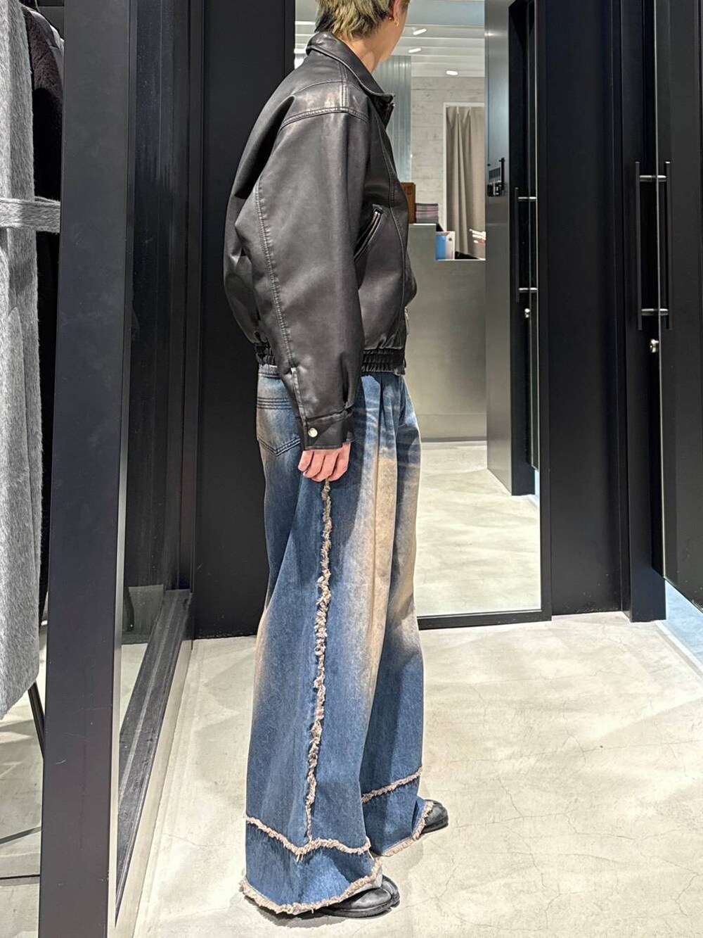 ブラック系のブルゾン、ブルー系のデニムパンツ、シルバー系のネックレスを着用したメンズの冬コーディネートの2枚目の写真