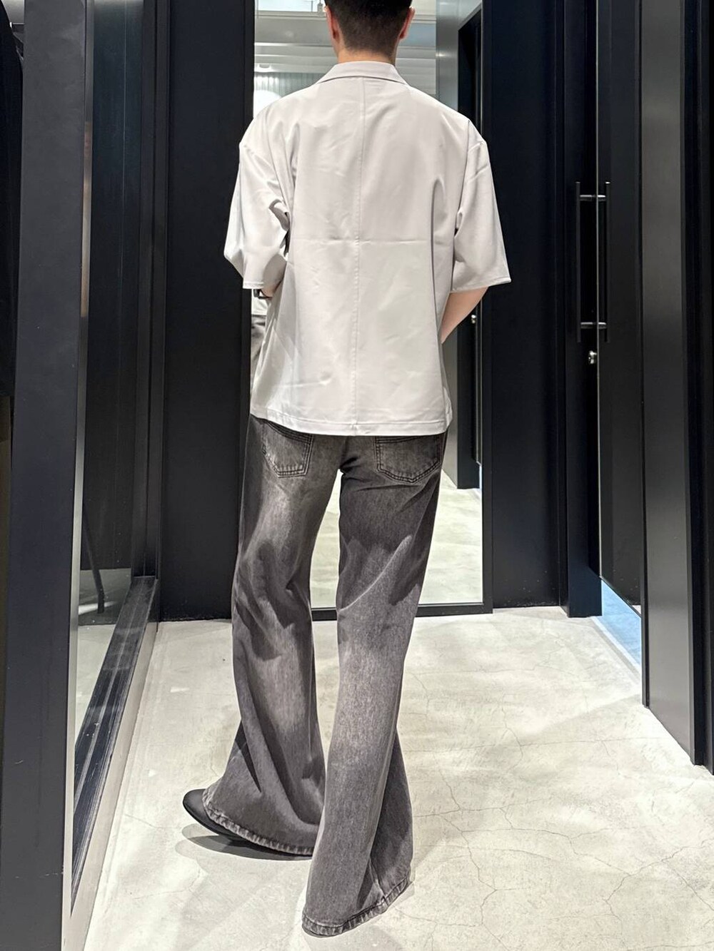 ブラック系のタンクトップ、ブラック系のバレエシューズ、グレー系のデニムパンツを着用したメンズの夏コーディネートの2枚目の写真