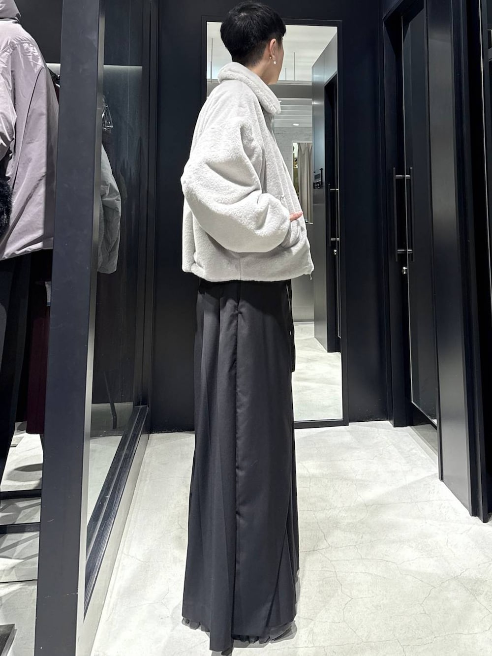 グレー系のブルゾン、ブラック系のスラックスを着用したメンズの冬コーディネートの2枚目の写真