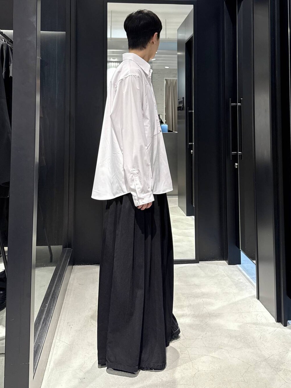 ホワイト系のTシャツ/カットソー、ブラック系のデニムパンツ、ブラック系のブーツを着用したメンズの秋コーディネートの2枚目の写真