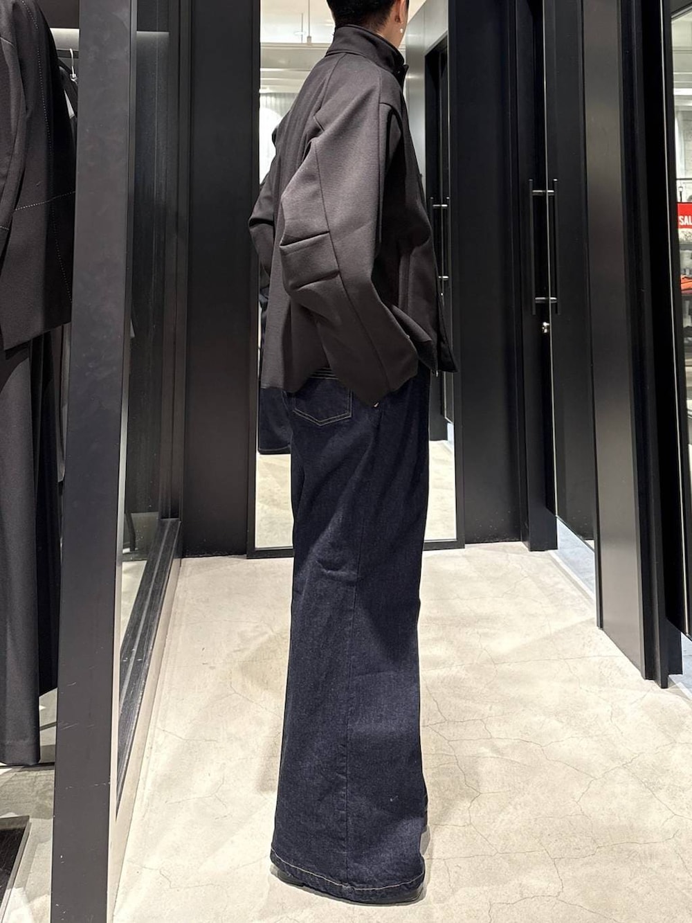 ブラック系のブーツ、ブルー系のデニムパンツ、ブラック系のブルゾンを着用したメンズの冬コーディネートの2枚目の写真