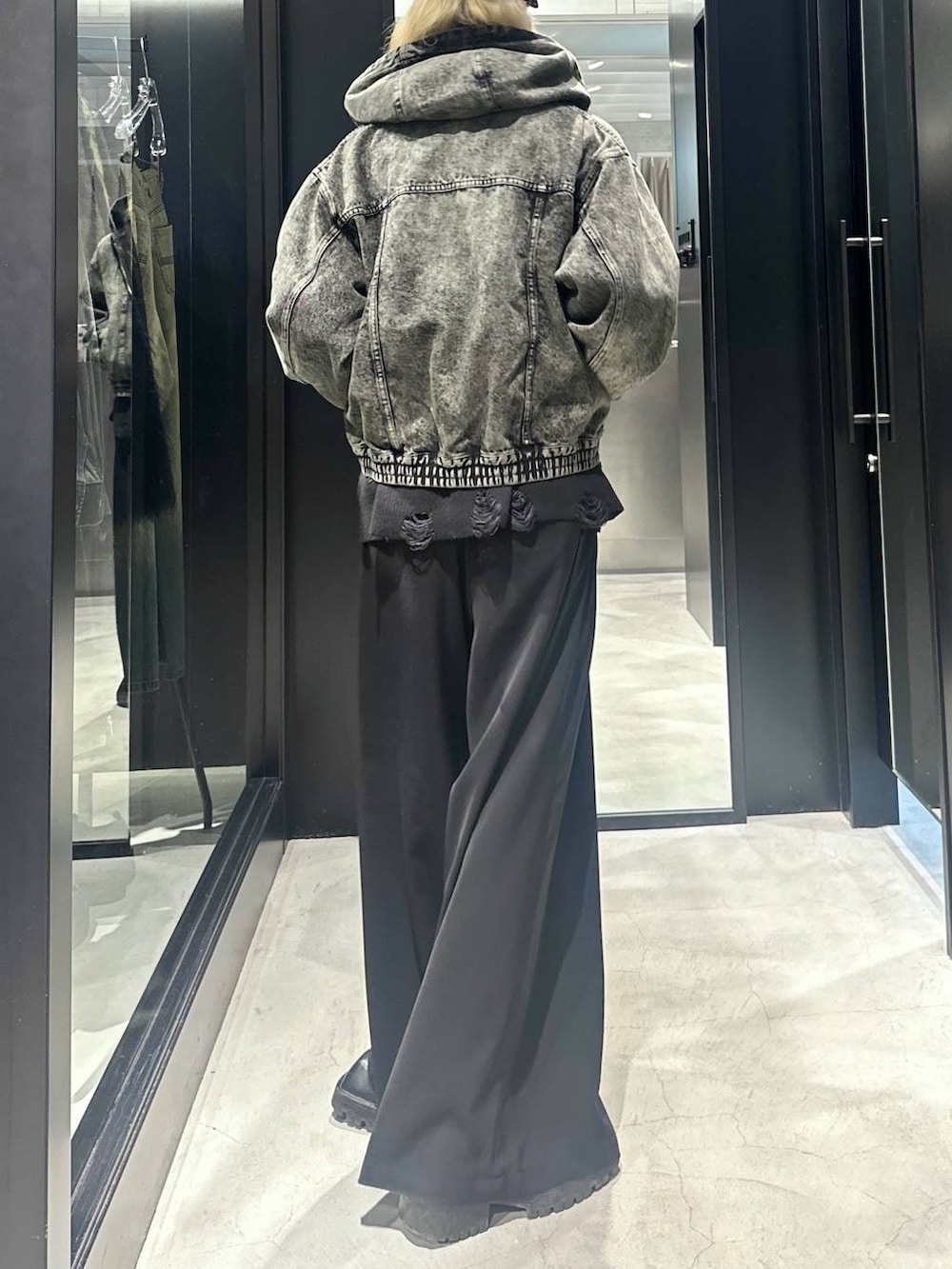 グリーン系のブルゾン、ブラック系のニット/セーター、ブラック系のスラックスを着用したメンズの秋コーディネートの3枚目の写真