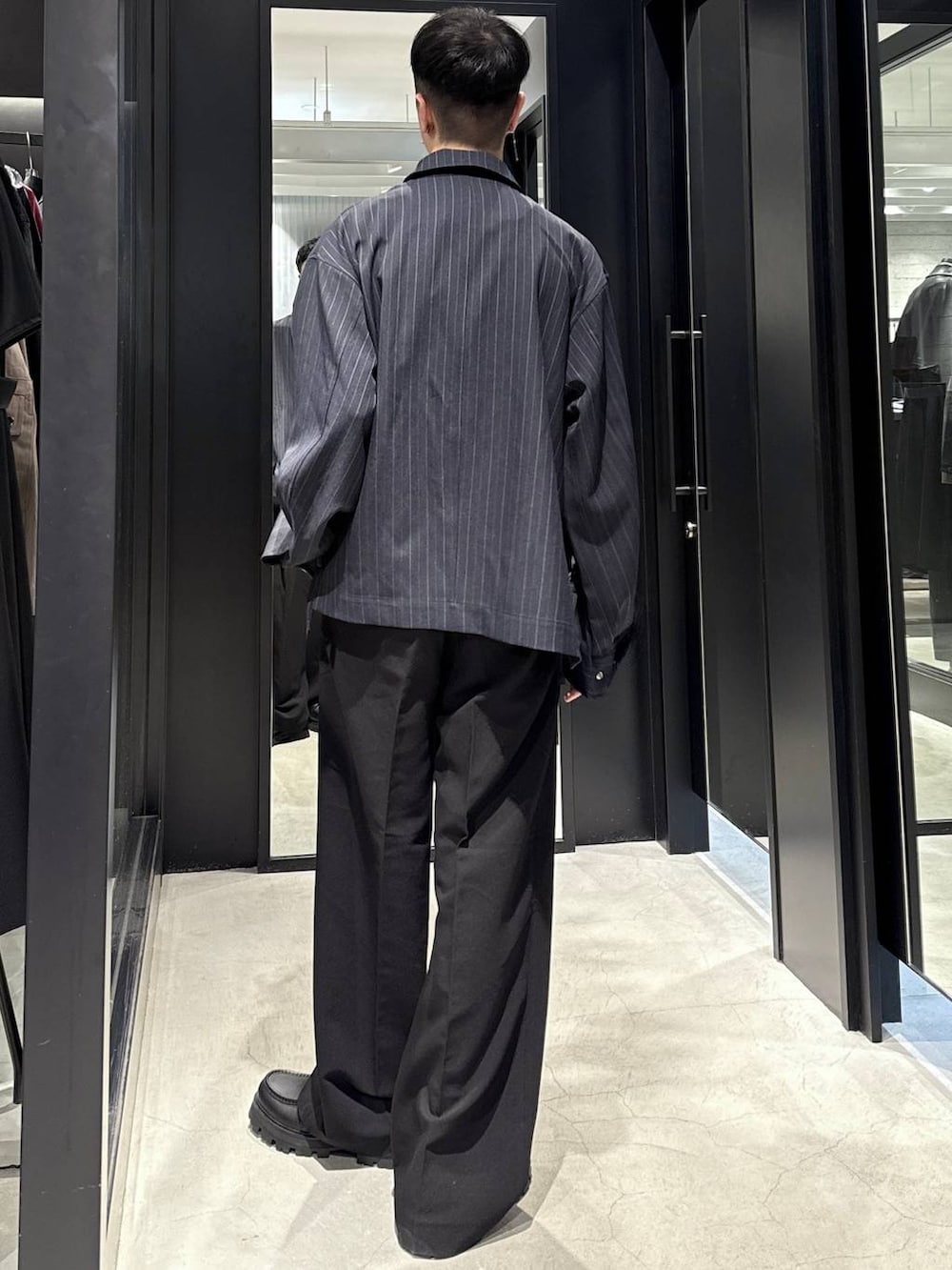 ブルー系のブルゾン、ブラック系のTシャツ/カットソー、ブラック系のドレスシューズを着用したメンズの秋コーディネートの3枚目の写真