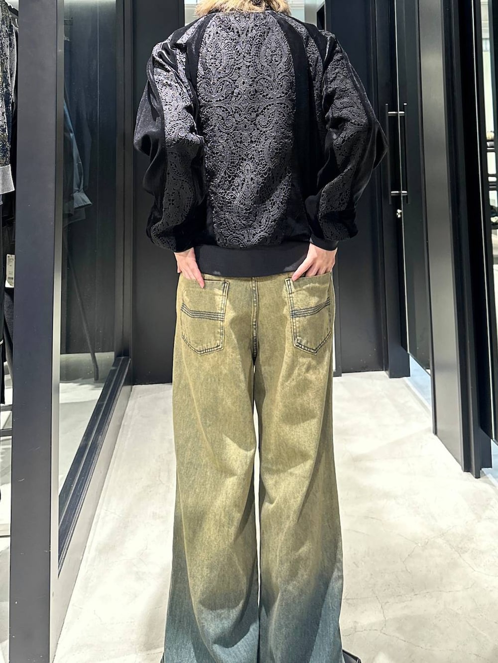 グリーン系のデニムパンツ、ブラック系のブルゾン、シルバー系のネックレスを着用したメンズの秋コーディネートの3枚目の写真