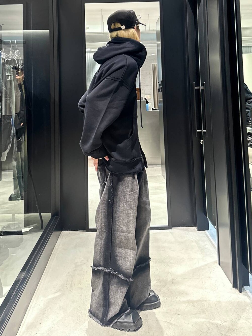 ブラック系のデニムパンツ、ブラック系のパーカー、ブラック系のキャップを着用したメンズの秋コーディネートの2枚目の写真