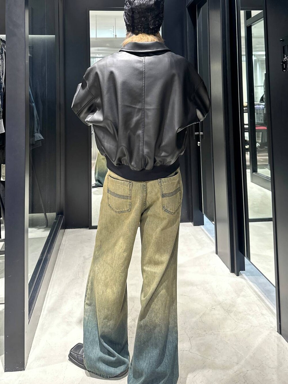 グリーン系のデニムパンツ、ブラック系のブルゾン、シルバー系のネックレスを着用したメンズの秋コーディネートの2枚目の写真