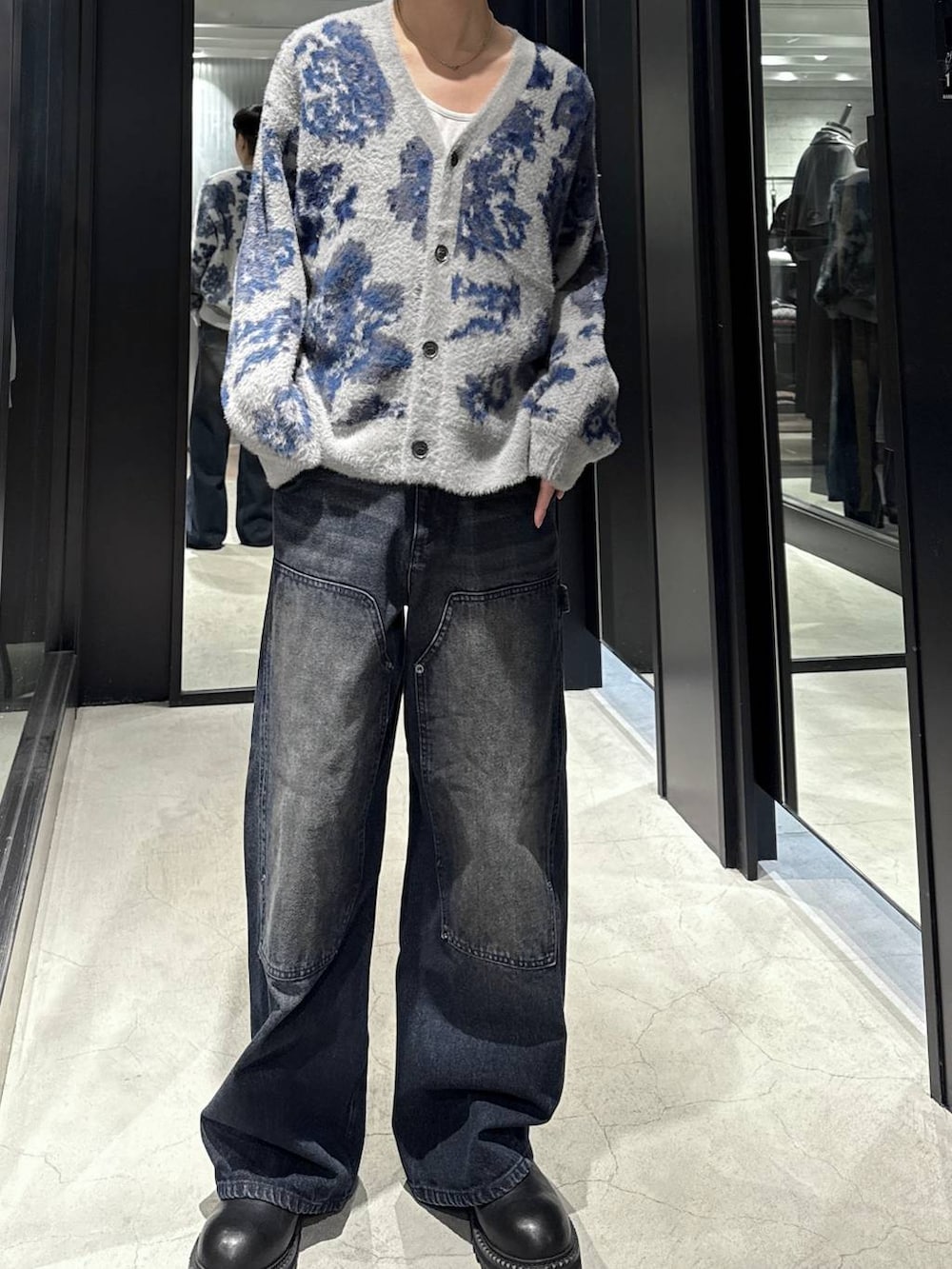 グレー系のカーディガン/ボレロ、ブラック系のブーツ、ブルー系のデニムパンツを着用したメンズの秋コーディネートの4枚目の写真