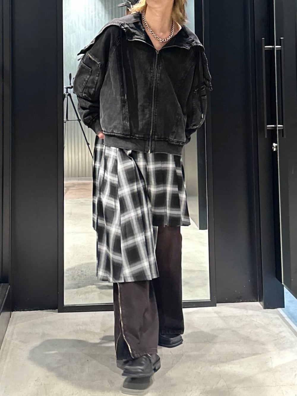 レッド系のデニムパンツ、グレー系のスカート、ブラック系のパーカーを着用したメンズの秋コーディネートの4枚目の写真