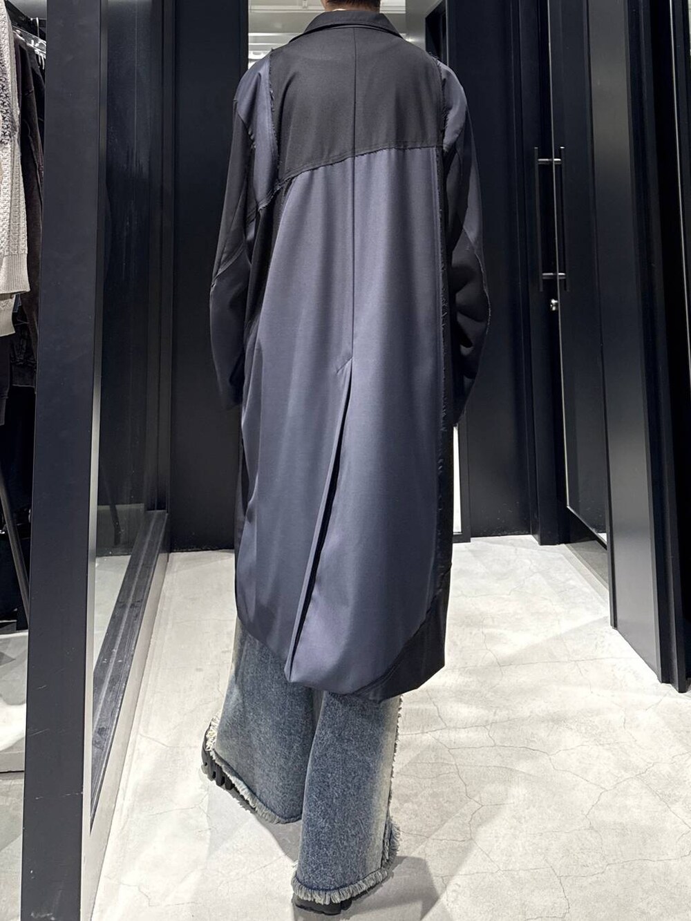 ブルー系のデニムパンツ、ブラック系のその他アウター、ホワイト系のネックレスを着用したメンズの冬コーディネートの4枚目の写真