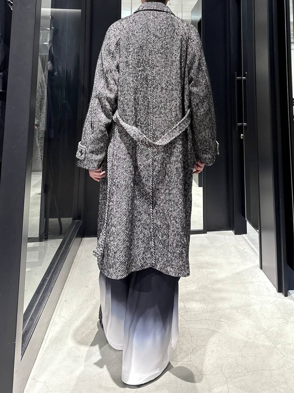 グレー系のステンカラーコート、ブラック系のその他パンツを着用したメンズの冬コーディネートの4枚目の写真