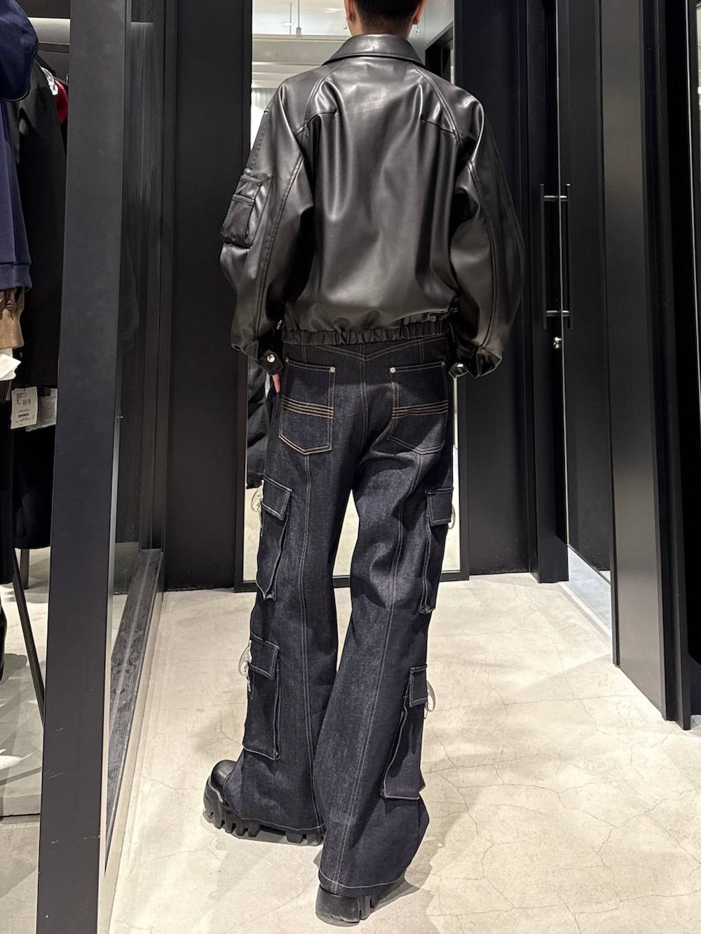 ブラック系のブルゾン、ブルー系のデニムパンツ、ホワイト系のネックレスを着用したメンズの冬コーディネートの3枚目の写真