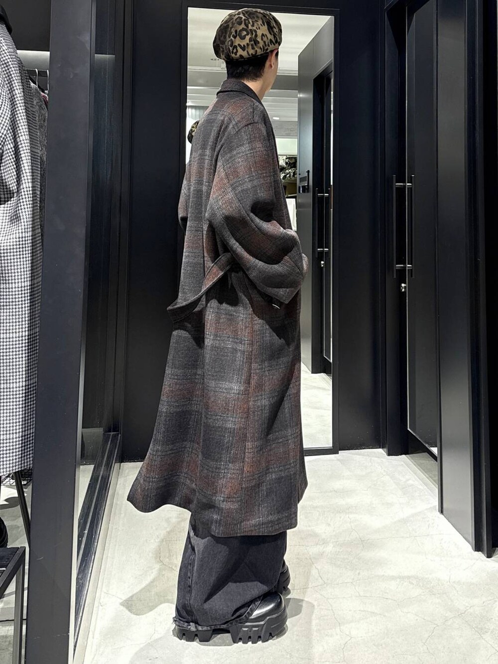 ブラック系のデニムパンツ、ブラック系のスウェット、グレー系のチェスターコートを着用したメンズの秋コーディネートの2枚目の写真