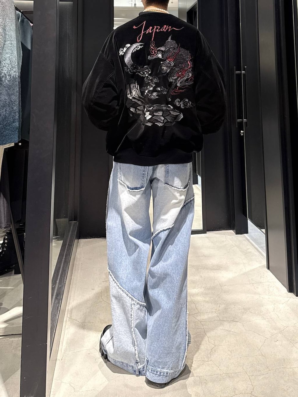 ブラック系のスカジャン、ホワイト系のネックレスを着用したメンズの冬コーディネートの3枚目の写真