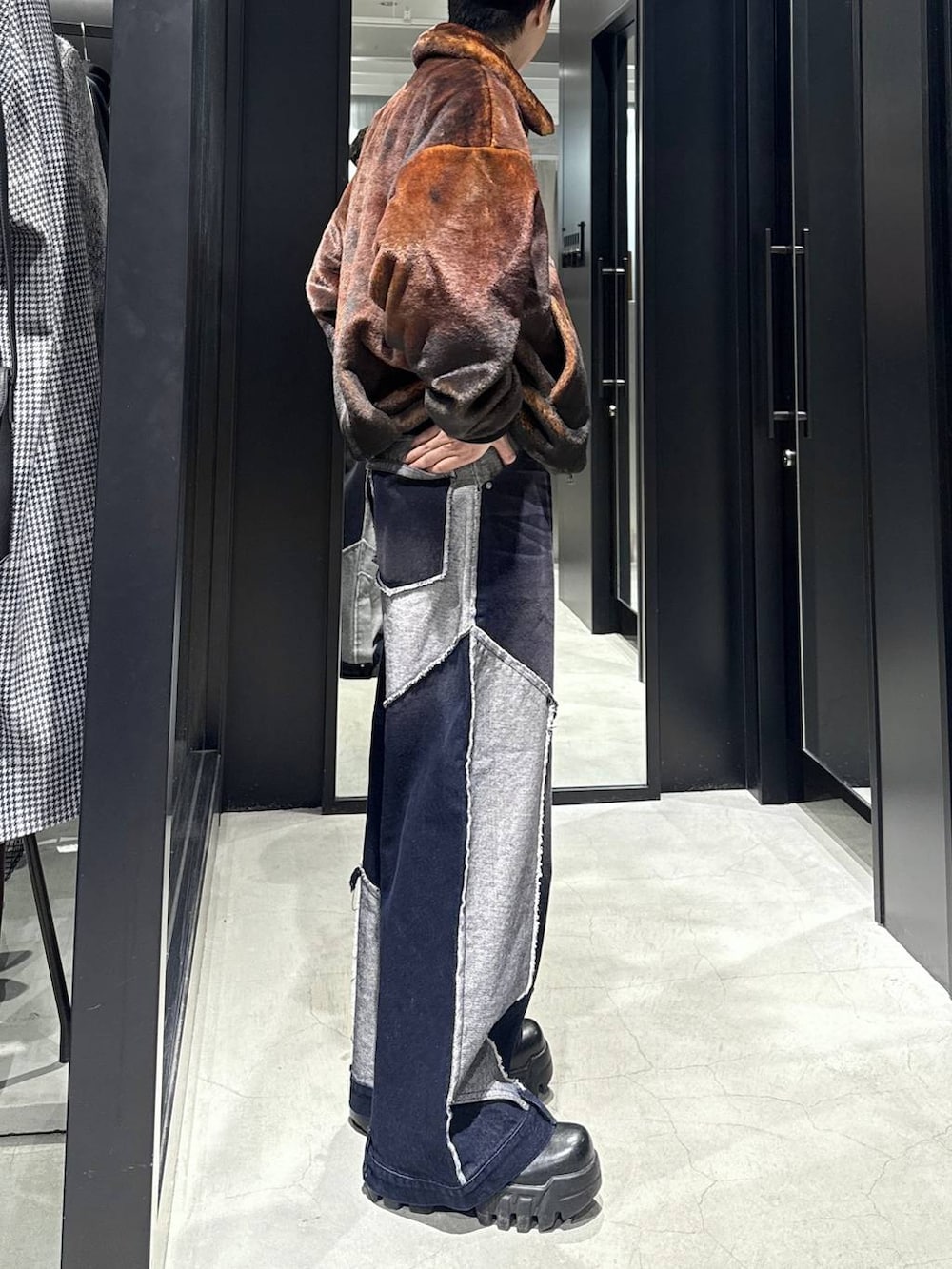 オレンジ系のブルゾン、ブルー系のデニムパンツを着用したメンズの秋コーディネートの2枚目の写真