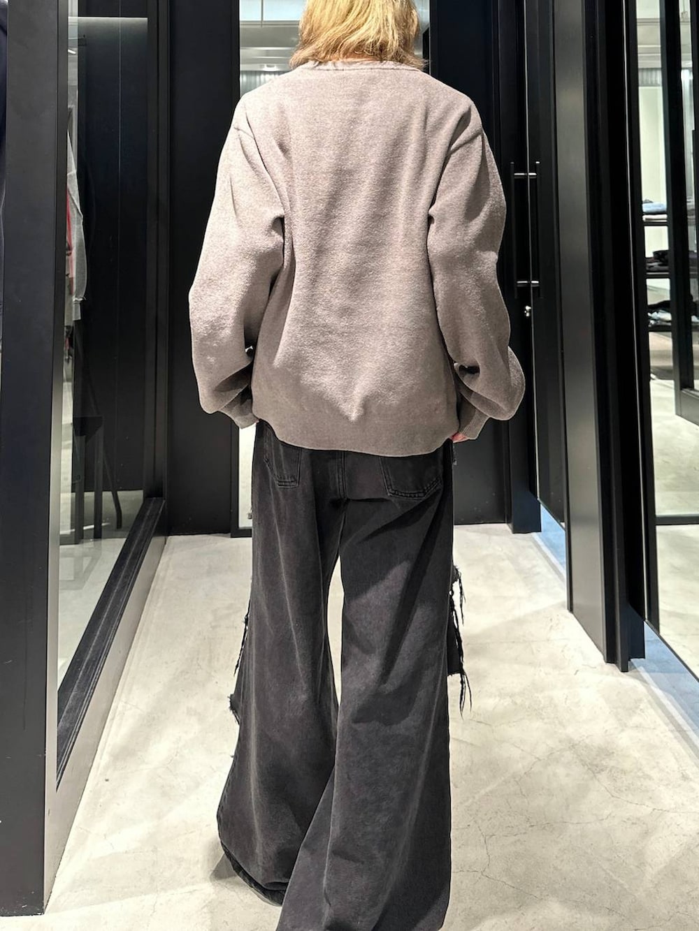 ブラック系のデニムパンツ、グレー系のニット/セーター、ブラック系のキャップを着用したメンズの秋コーディネートの3枚目の写真