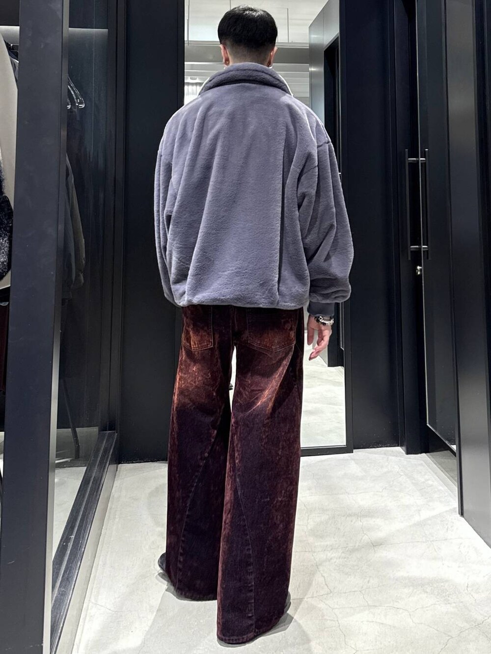 パープル系のブルゾン、レッド系のデニムパンツを着用したメンズの秋コーディネートの3枚目の写真