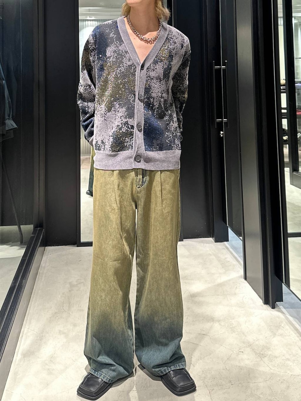 グリーン系のデニムパンツ、グレー系のカーディガン/ボレロ、シルバー系のネックレスを着用したメンズの秋コーディネートの2枚目の写真