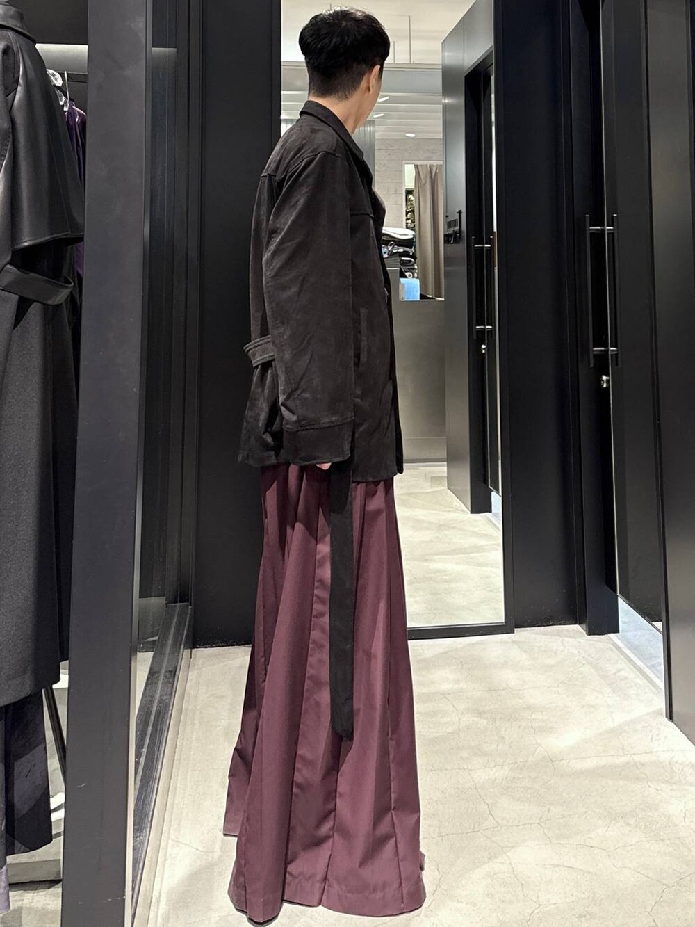 ブラック系のブーツ、レッド系のその他パンツ、ブラック系のミリタリージャケットを着用したメンズの秋コーディネートの2枚目の写真