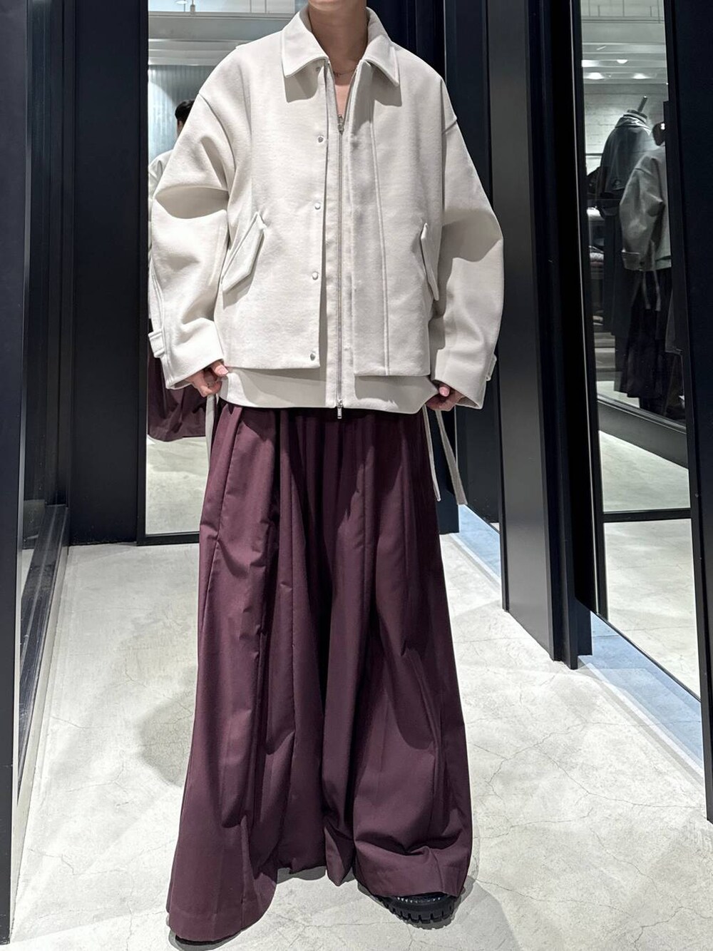 ホワイト系のブルゾン、ブラック系のブーツ、レッド系のその他パンツを着用したメンズの秋コーディネートの4枚目の写真