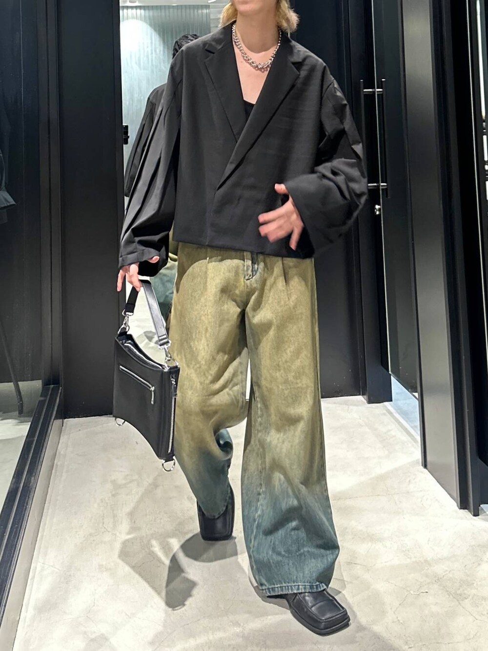 グリーン系のデニムパンツ、ブラック系のショルダーバッグ、ブラック系のテーラードジャケットを着用したメンズの秋コーディネートの2枚目の写真