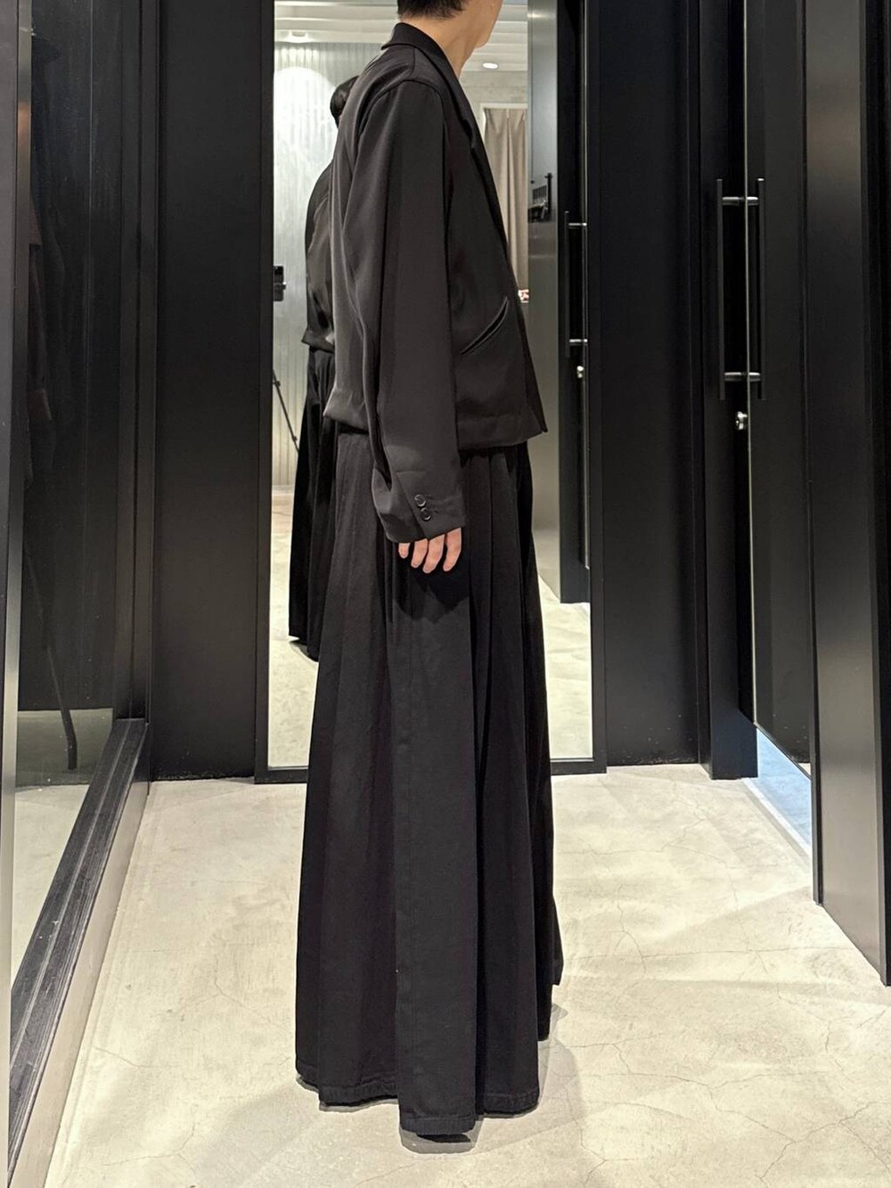 ホワイト系のTシャツ/カットソー、ブラック系のテーラードジャケット、ブラック系のデニムパンツを着用したメンズの秋コーディネートの2枚目の写真