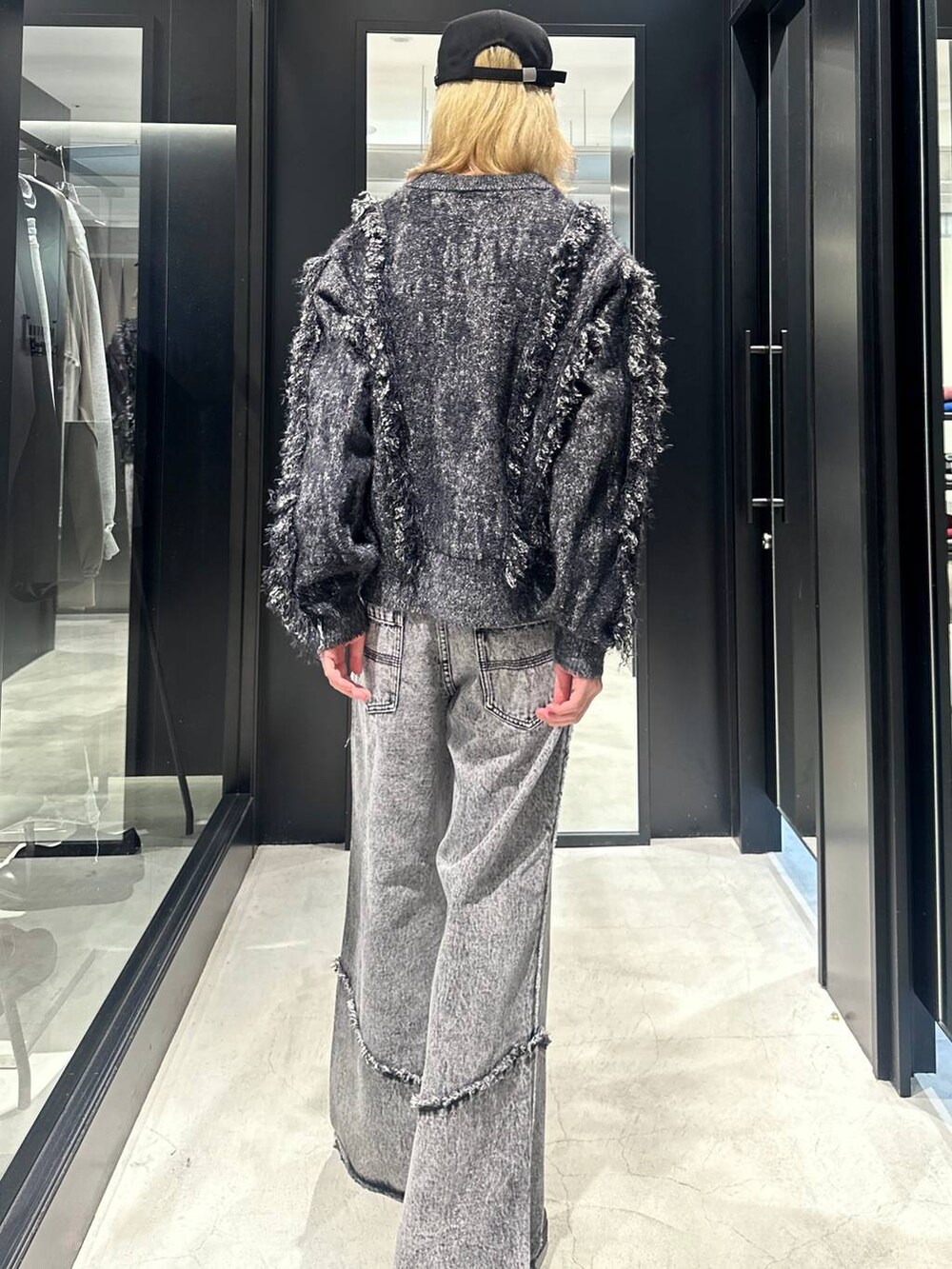 グレー系のデニムパンツ、ブラック系のブーツ、ブラック系のブルゾンを着用したメンズの秋コーディネートの4枚目の写真