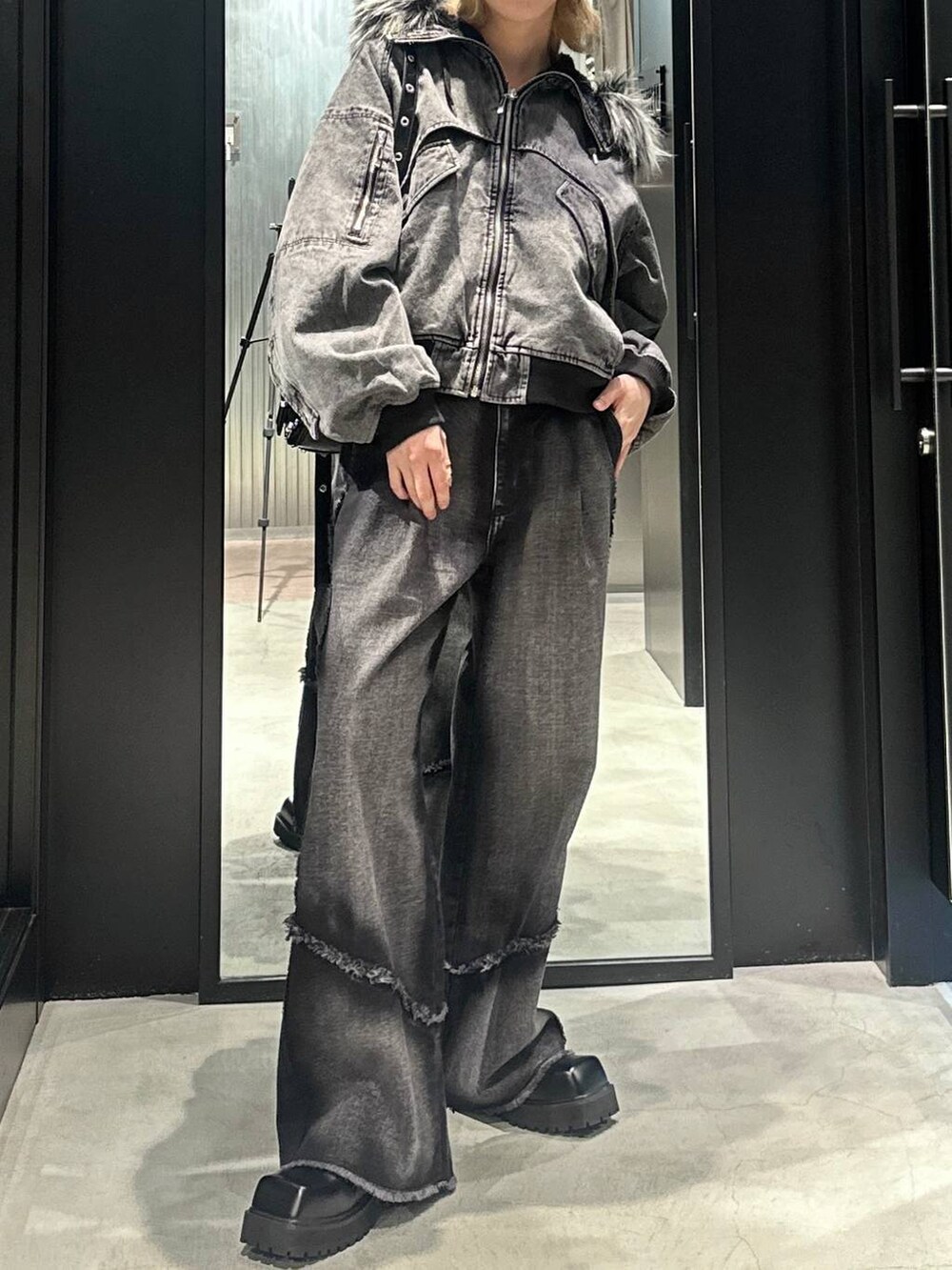 ブラック系のデニムパンツ、ブラック系のショルダーバッグ、グレー系のブルゾンを着用したメンズの秋コーディネートの3枚目の写真