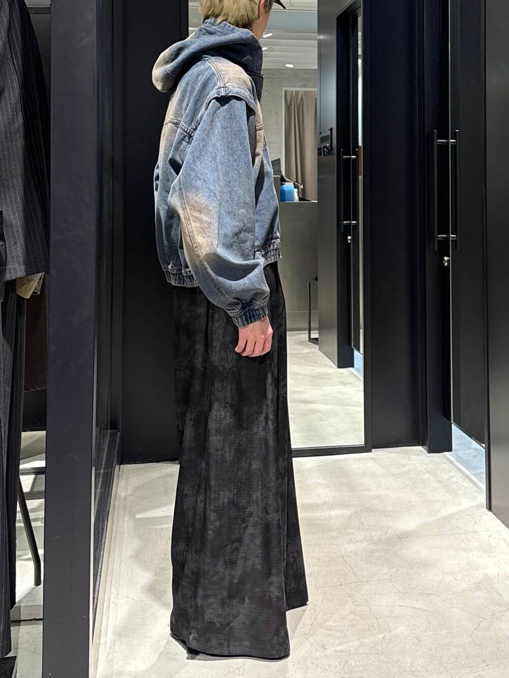 ブラック系のTシャツ/カットソー、グレー系のスラックス、ブルー系のブルゾンを着用したメンズの冬コーディネートの2枚目の写真