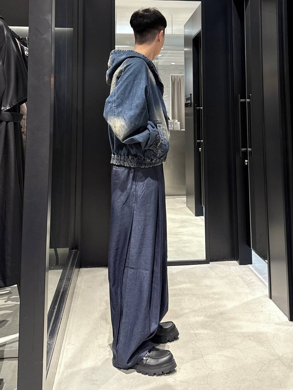 ブルー系のスラックス、ブラック系のTシャツ/カットソー、ブラック系のドレスシューズを着用したメンズの秋コーディネートの2枚目の写真