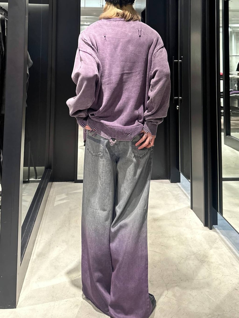 パープル系のデニムパンツ、パープル系のニット/セーター、シルバー系のネックレスを着用したメンズの秋コーディネートの5枚目の写真