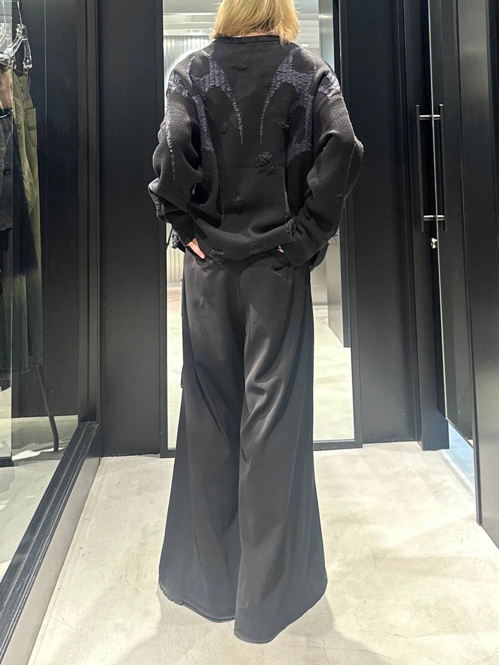 ブラック系のニット/セーター、ブラック系のスラックス、ブラック系のキャップを着用したメンズの秋コーディネートの2枚目の写真