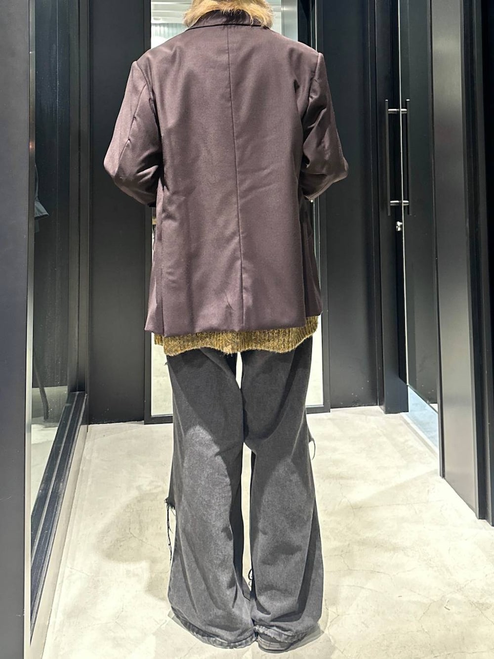 ブラック系のデニムパンツ、ブラウン系のテーラードジャケット、イエロー系のニット/セーターを着用したメンズの秋コーディネートの2枚目の写真