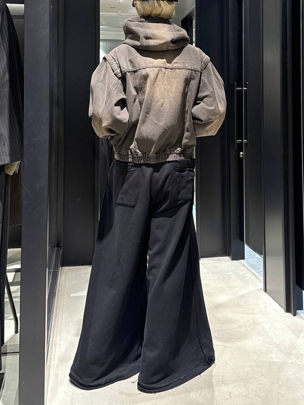ブラック系のTシャツ/カットソー、ブラック系のスウェットパンツ、ブラウン系のブルゾンを着用したメンズの冬コーディネートの3枚目の写真