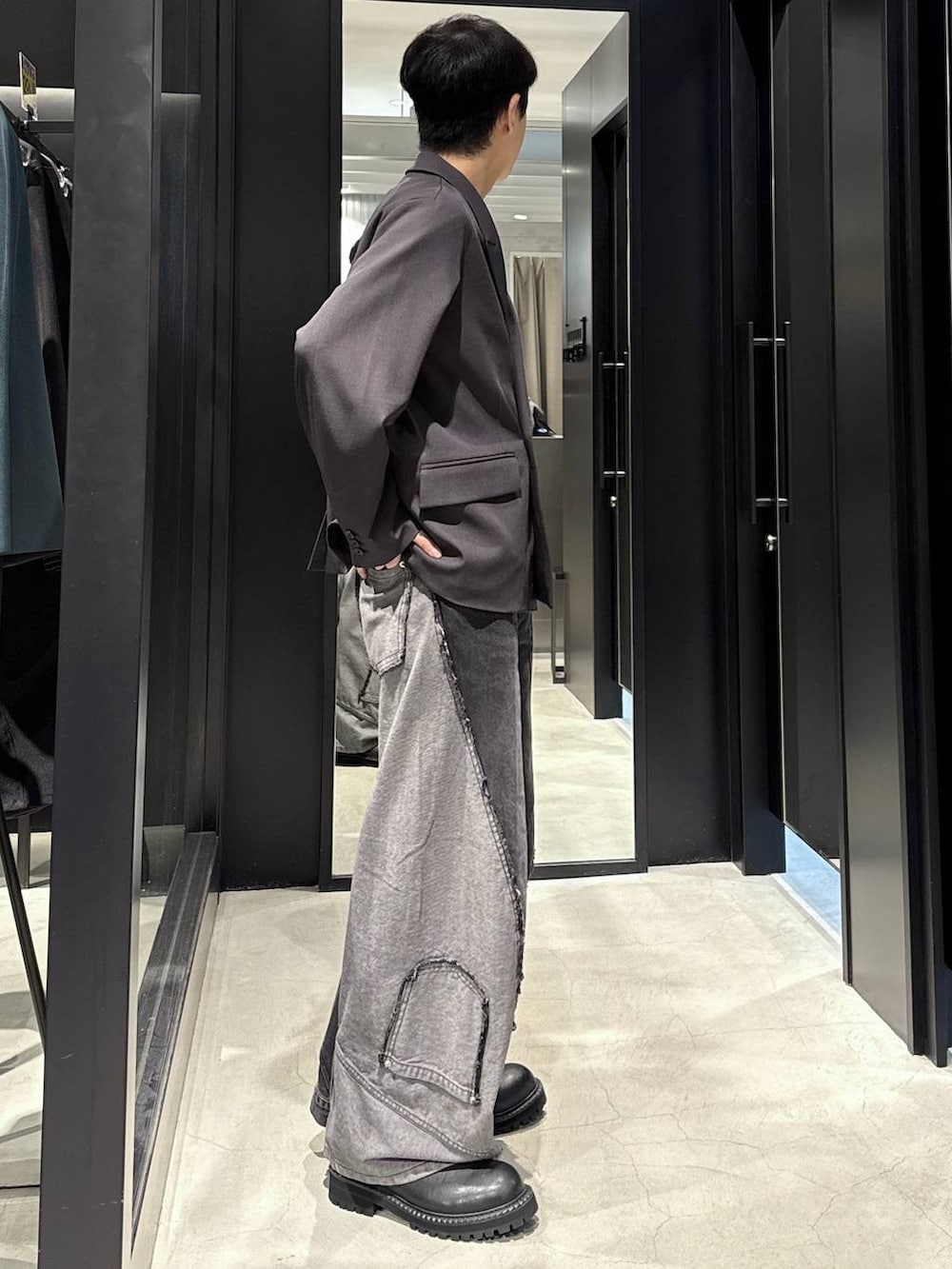 ブラック系のデニムパンツ、ブラック系のTシャツ/カットソー、ブラック系のブーツを着用したメンズの秋コーディネートの2枚目の写真